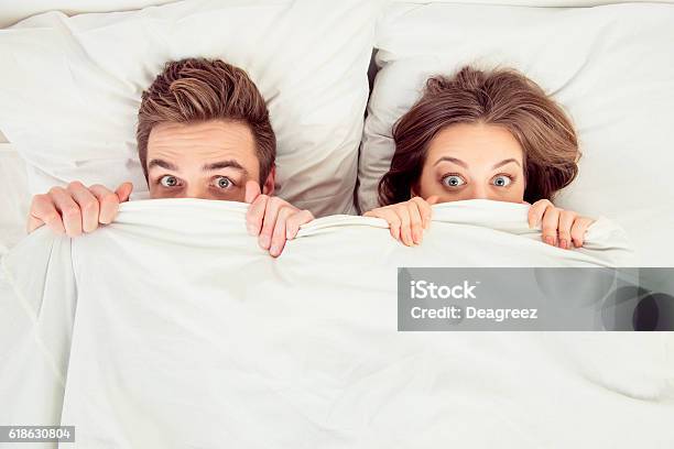 Überrascht Lustige Paar In Liebe Liegen Datauf Bett Unter Decke Stockfoto und mehr Bilder von Paar - Partnerschaft