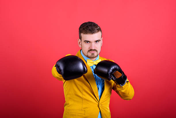 uomo in giacca gialla e guanti da boxe - signal box foto e immagini stock