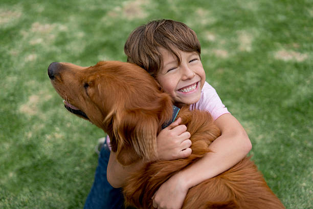 美しい犬と幸せな少年 - pets embracing one person portrait ストックフォトと画像