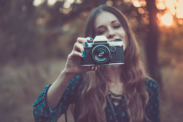 Pretty girl with vintage camera in park stock photo