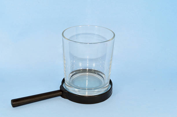 istock Empty Glass over a magnifying glass meaning search for water 618637848