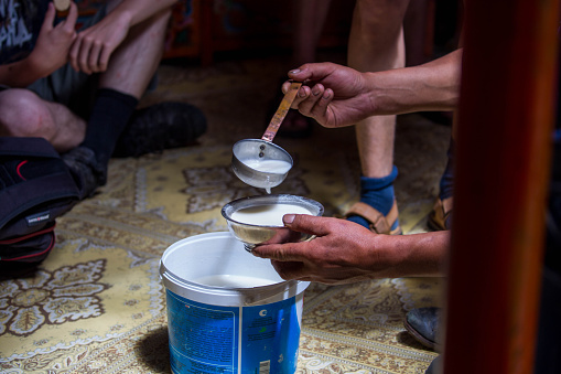 Arvaikheer, Mongolia - July 10, 2016: Pouring a drinking bowl of airag, a traditional Mongolian alcoholic drink made from fermented milk.