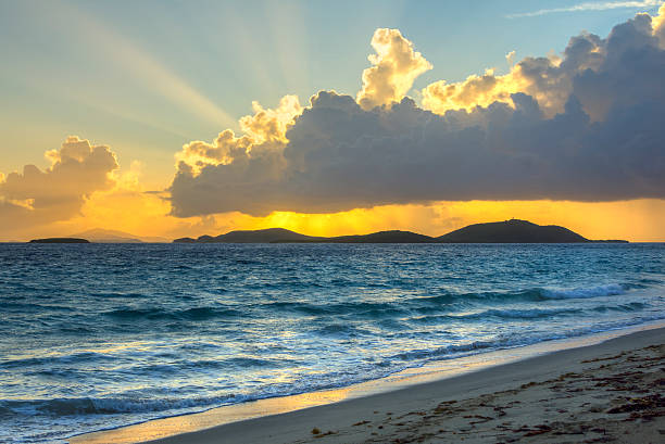 Morning rays shine over Caribbean island beach Vivid rays from rising sun shine brilliantly from behind clouds over tropical Caribbean island of Culebrita and reflect on sea and Zoni Beach on Isla Culebra culebra island photos stock pictures, royalty-free photos & images