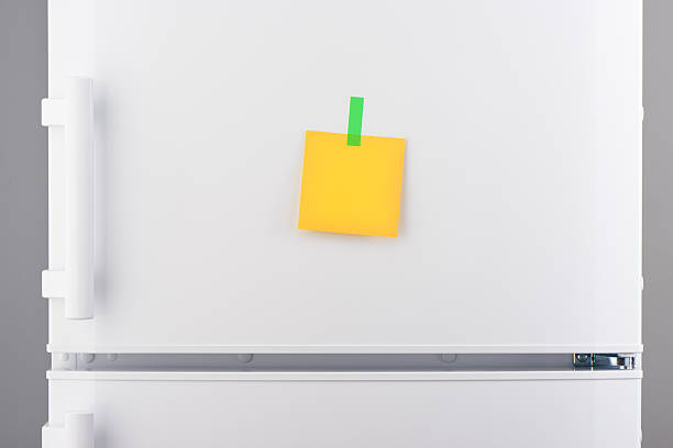 istock Blank yellow paper note and green sticker on white refrigerator 618641846