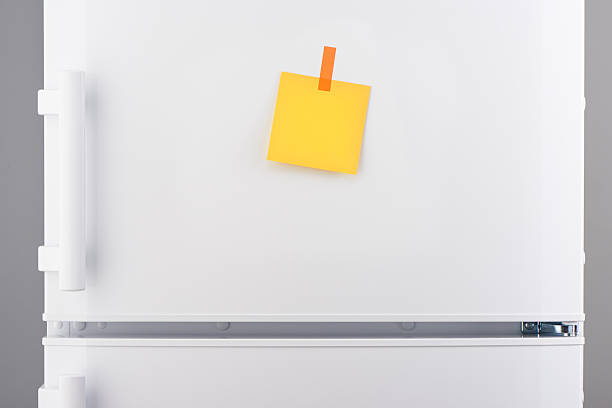 istock Blank yellow paper note and orange sticker on white refrigerator 618641896