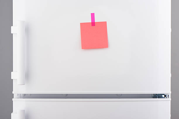 istock Blank pink paper note and pink sticker on white refrigerator 618641912