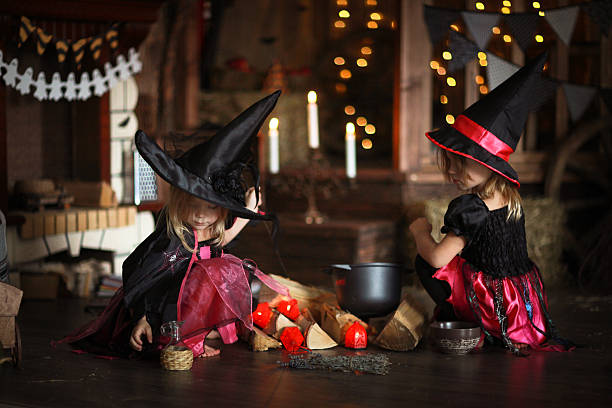 istock Two little Halloween  witches reading conjure above pot   childh 618643702