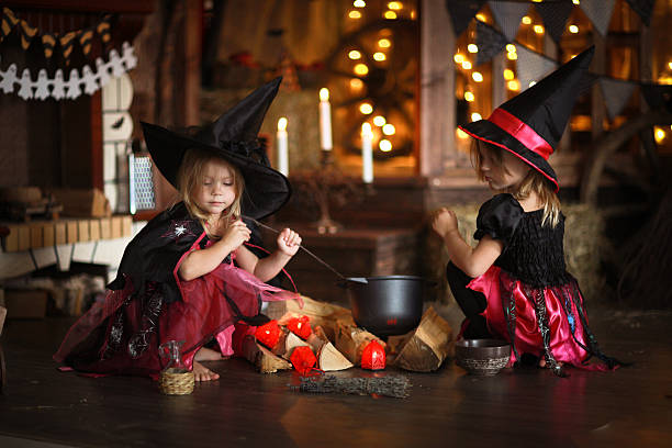 istock Two little Halloween  witches reading conjure above pot   childh 618643746