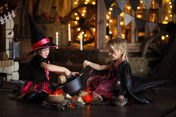 istock Two little Halloween  witches reading conjure above pot   childh 618644518