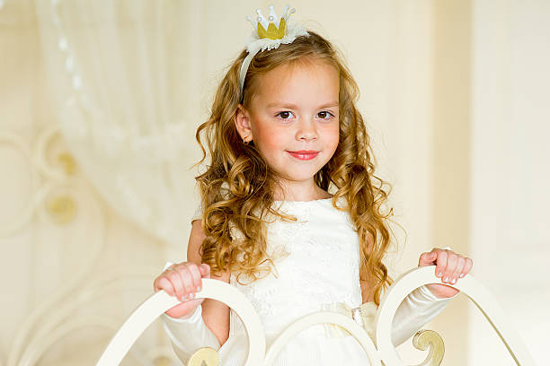 little princess on the bed in classic dress and vintage atmosphere of the room