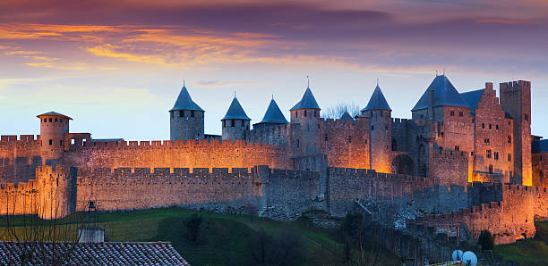 la ville fortifiée en soirée.  carcassonne - antiquary photos et images de collection