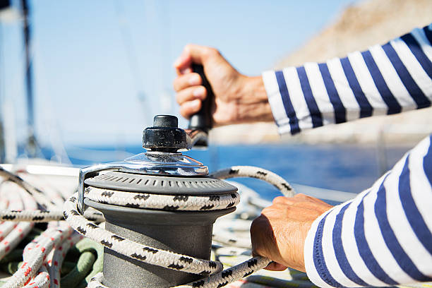 mann in aktion ziehen seil - cable winch sailing yacht sport stock-fotos und bilder