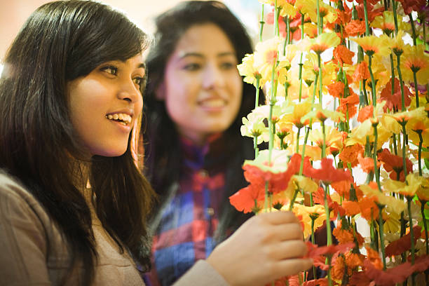 les filles achètent des tentures murales florales dans la boutique de décoration avant le festival. - vertical single flower women teenager photos et images de collection