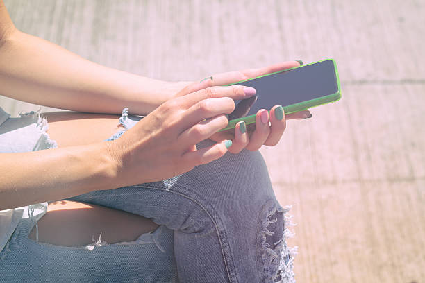 istock Girl texting while sitting on the bench outdoors. 618650762