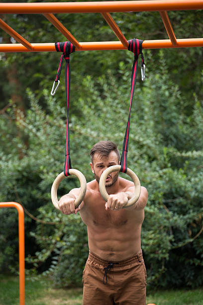 istock Muscular man exercising on outdoor gymnastic ring. 618651812