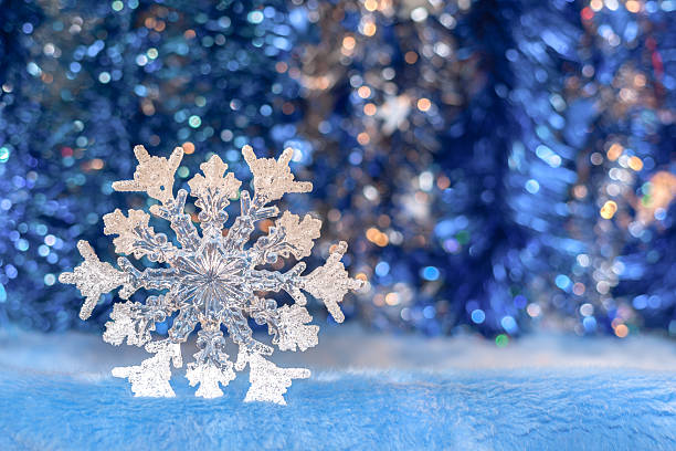 istock Christmas toy snowflake on sparkling bright blue bokeh background. 618720088
