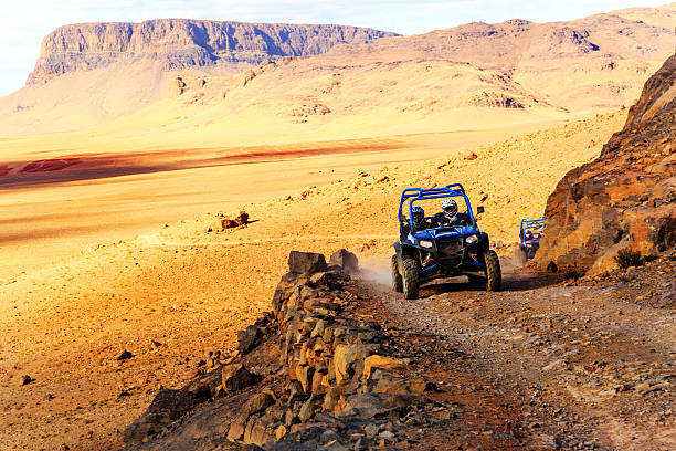 polaris rzr 800 azul cruzando una carretera de montaña - off road vehicle quadbike desert dirt road fotografías e imágenes de stock