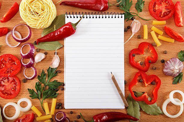 istock notebook for recipes, vegetables and spices on wooden table. 618724314