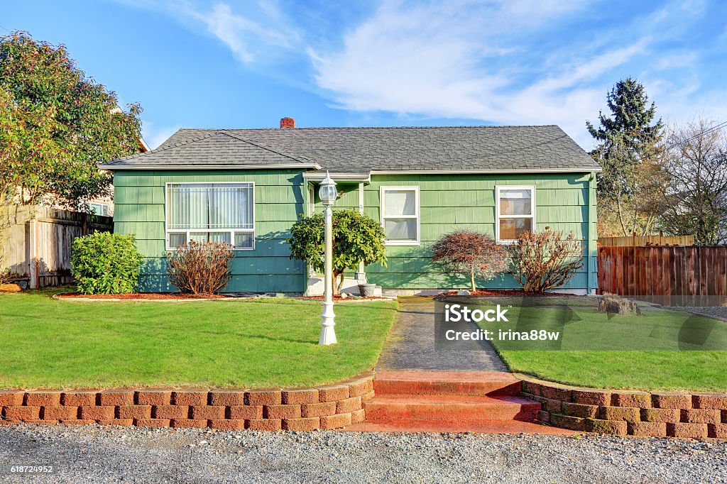 Green Suburban Bungalow style home Green Suburban Bungalow style home on blue sky background. Northwest, USA Outdoors Stock Photo