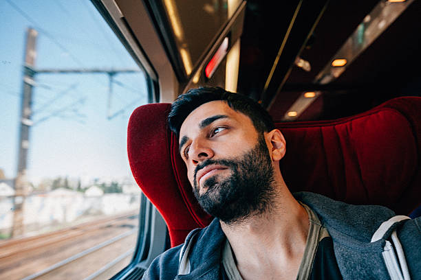 istock Young Man Traveling In Train - Lost in thought 618725304