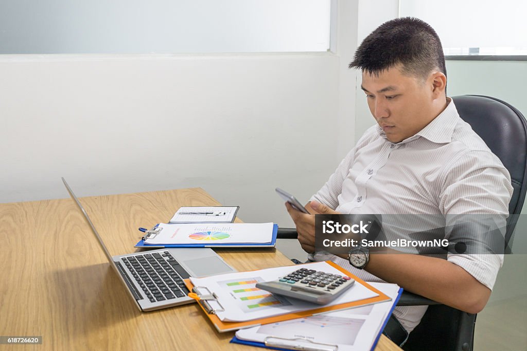 Texting message on smartphone make him lose concentration on working Adult Stock Photo