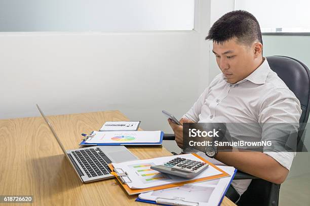 Texting Message On Smartphone Make Him Lose Concentration On Working Stock Photo - Download Image Now