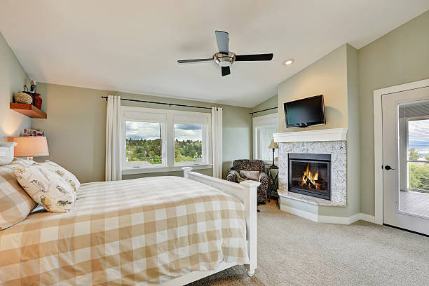 istock Master bedroom interior with fireplace and light olive walls. 618727274