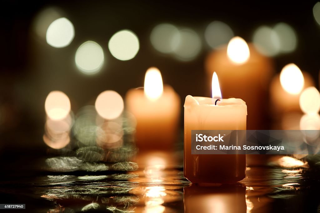 Candle with reflection Burning candle with reflection against candlelight background Candle Stock Photo
