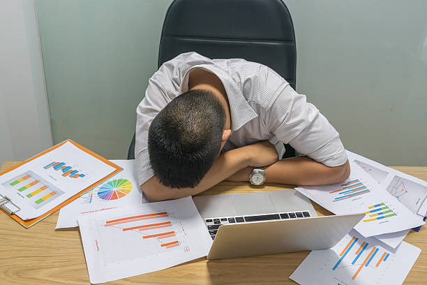 istock Tired office man taking short nap at work place 618728524
