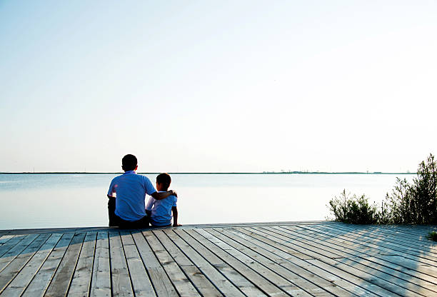 istock Father with his son enjoying lake view 618733682