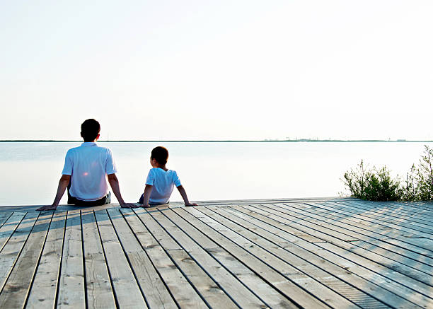 istock Father with his son enjoying lake view 618734084