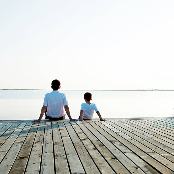 istock Father with his son enjoying lake view 618734226