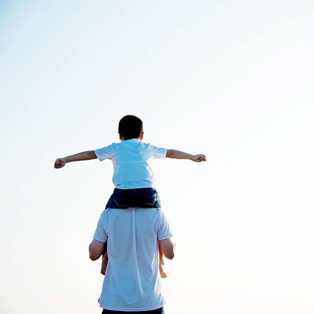 istock Father carrying his son on shoulders 618735186