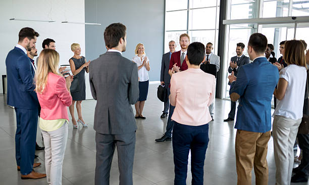 istock leader standing in front of his partners who applauding 618735436