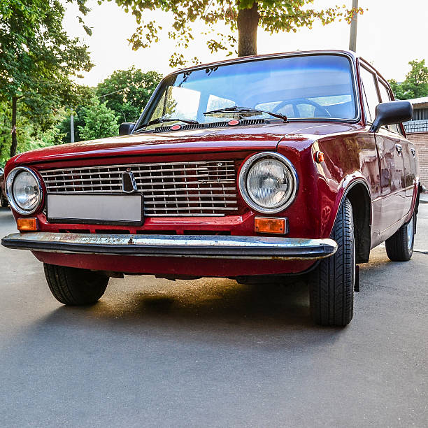 istock Red vintage car parked under tree at sunset 618736186