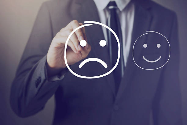 customer choosing to write unhappy face over happy face - moppert stockfoto's en -beelden