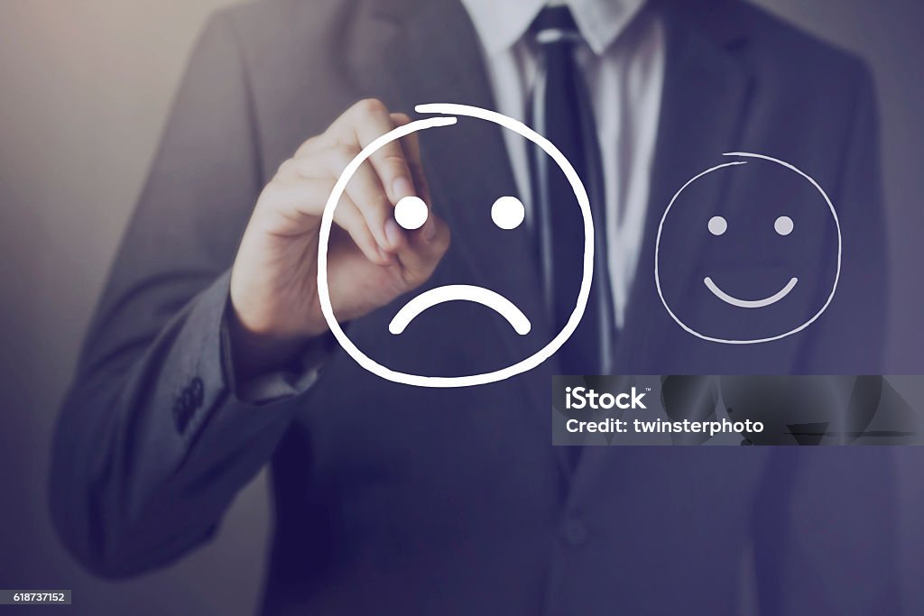 Customer choosing to write unhappy face over happy face Customer choosing to write unhappy face over happy face on virtual screen Complaining Stock Photo