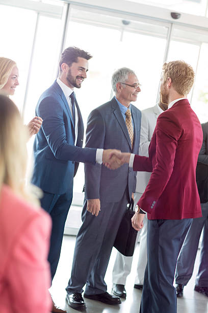 istock smiling business partners handshaking with leader 618737382