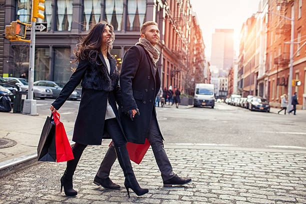 Young couple with shopping bags walking on street stock photo