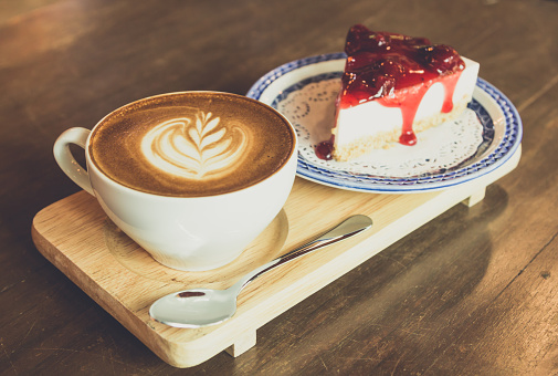 strawberry  cheese cake    and latte coffee  on wood table,vintage tone