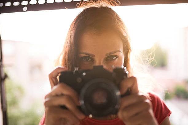 istock Beautiful woman holding camera 618738534