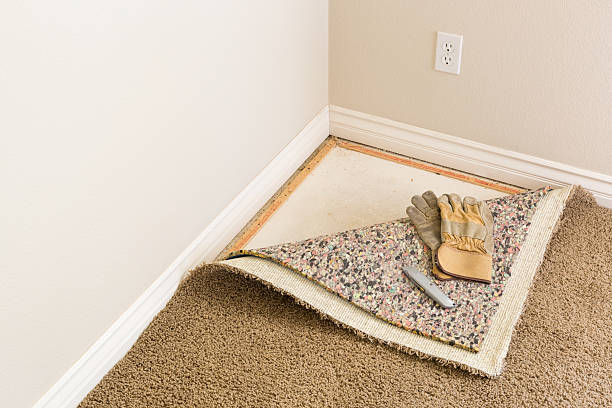 перчатки, утилита нож на вытащил назад ковер pad в комнате. - carpet installation стоковые фото и изображения