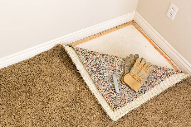 istock Gloves, Utility Knife and Pulled Back Carpet Pad In Room. 618739082