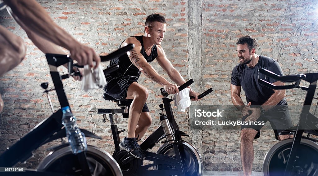 Bicycle exercising Bicycle exercising, young people on exercise bicycle Spinning Stock Photo