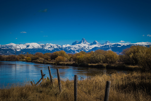 The view of the very still Teton River with the Teton Mountains far off in the background.