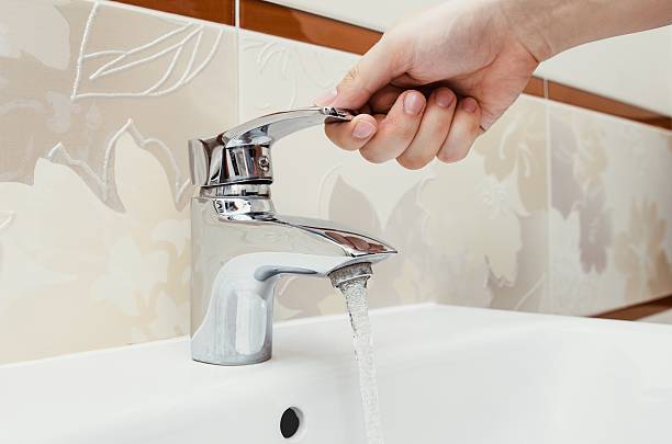 istock Man unscrew the faucet in the bathroom. 618740794