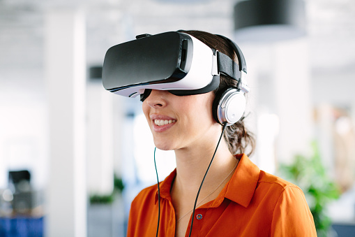 Closeup shot of young woman using virtual reality glasses in creative office
