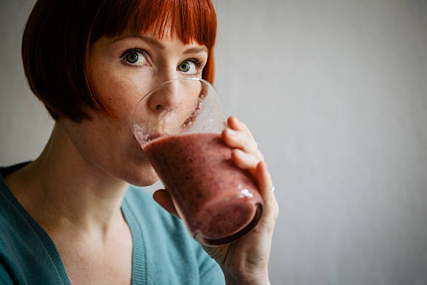 istock Red haired woman drinking smoothie 618744600
