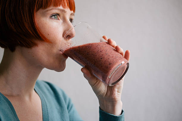 Red haired woman drinking smoothie