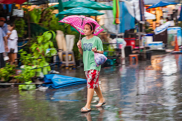Bangkok, Thailand - May 10, 2009: people in blurred motion at  at  Chatuchak  weekend market in rain Bangkok, Thailand. It is the largest market in Thailand with  more than 8000 stalls.